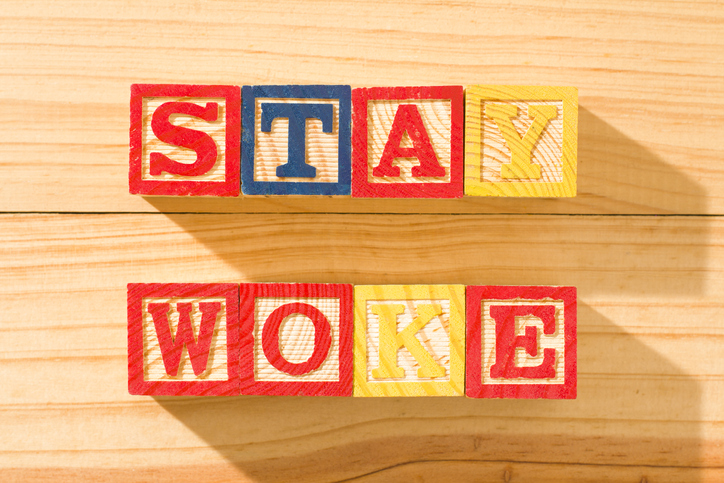 Wooden cubes with the word STAY WOKE on a wooden surface