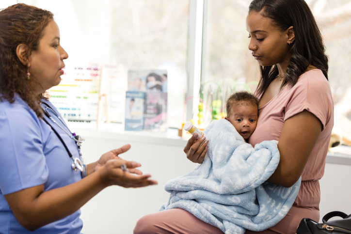 Female doctor explains dosage and side effects to young mom