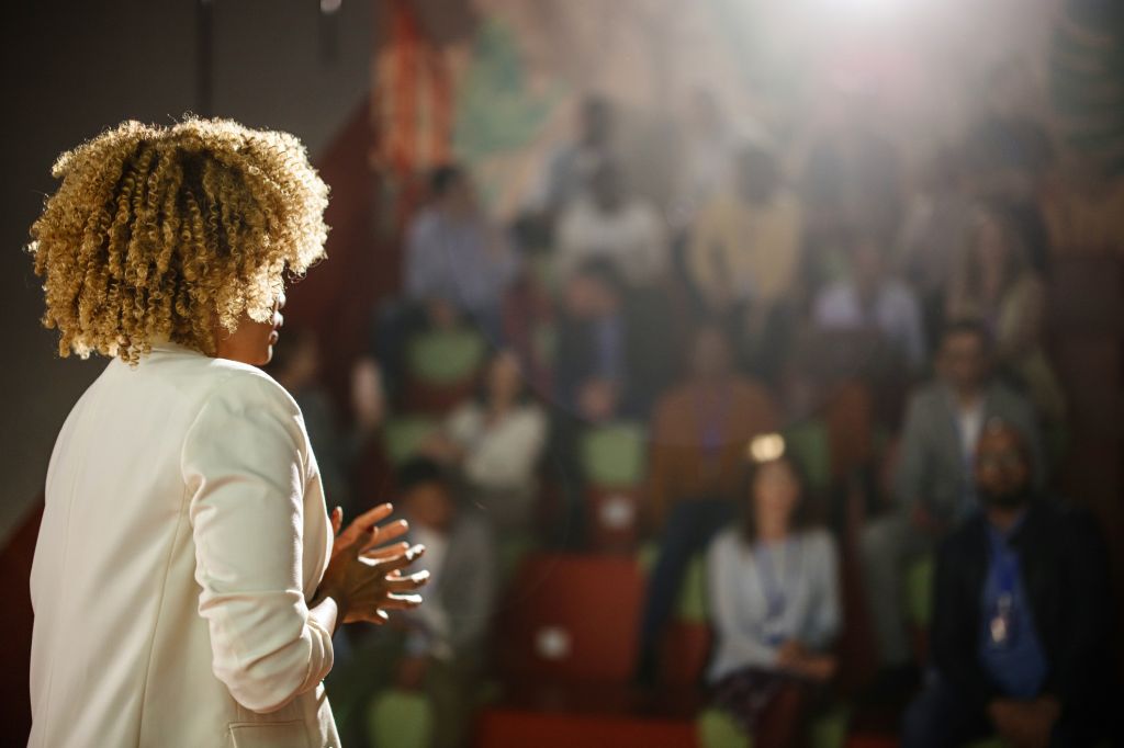 Rear view of the conference speaker giving talk at conference event