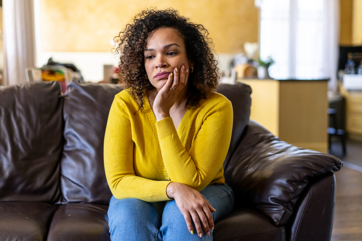 A grieving woman sitting on a couch