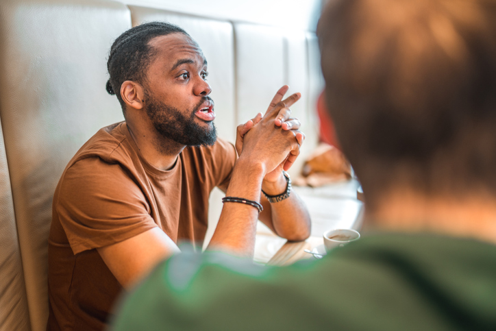 Mid Adult Hipster of African Descent Explaining Something at Lunch