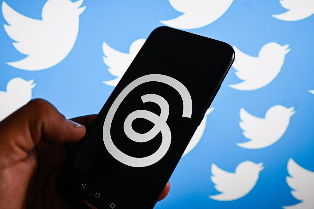 In this photo illustration, the Threads logo by META is...