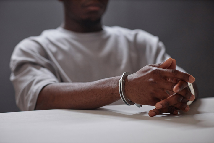 Close up of Black young man wearing handcuffs as arrested criminal