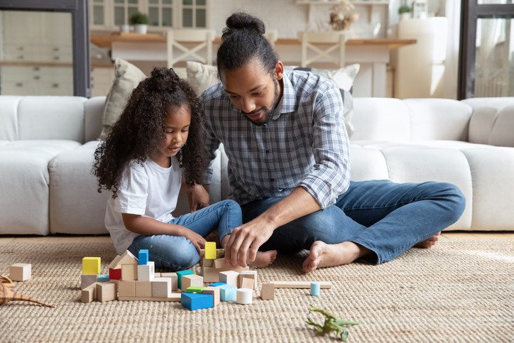 Happy African dad and daughter girl completing construction model