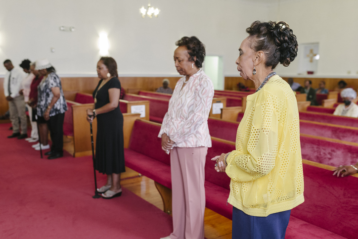 Church Members Standing in Prayerful Contemplation