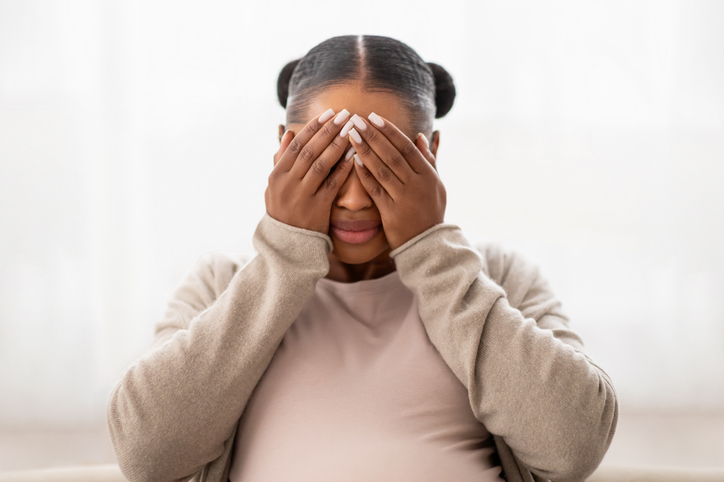 Closeup of african american pregnant lady crying at home