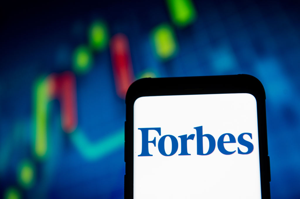 In this photo illustration a Forbes logo seen displayed on a...