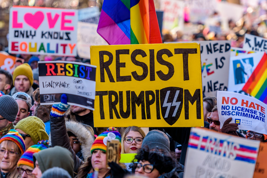 Protester holding a Resist Trumpism sign. Thousands of LGBTQ...
