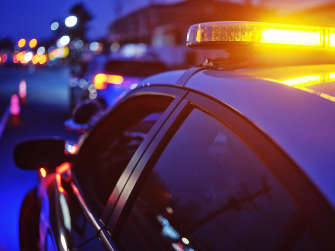 Police Car Stopped on a Road at Night with Emergency Lights