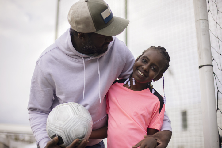 A 9 year old footballer girl posing with her dad