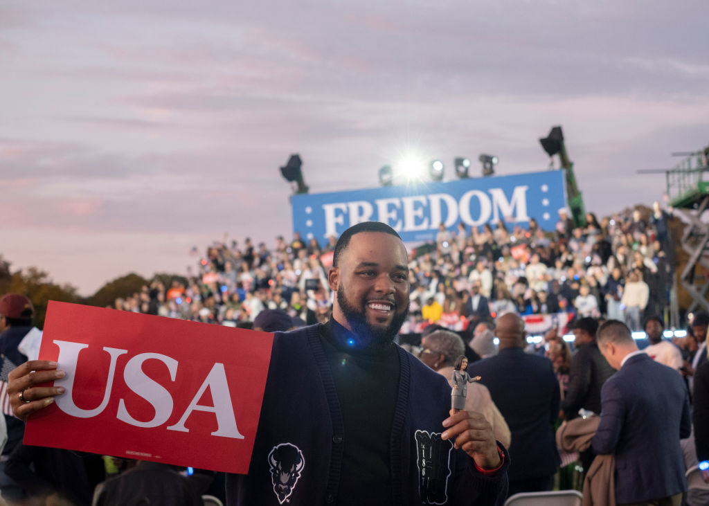 A supporter holding a sign with U.S.A is written on it,...
