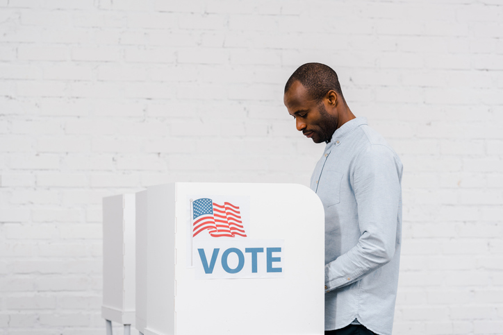 African american ethnicity citizen cast ballot at modern polling booth during a democratic election