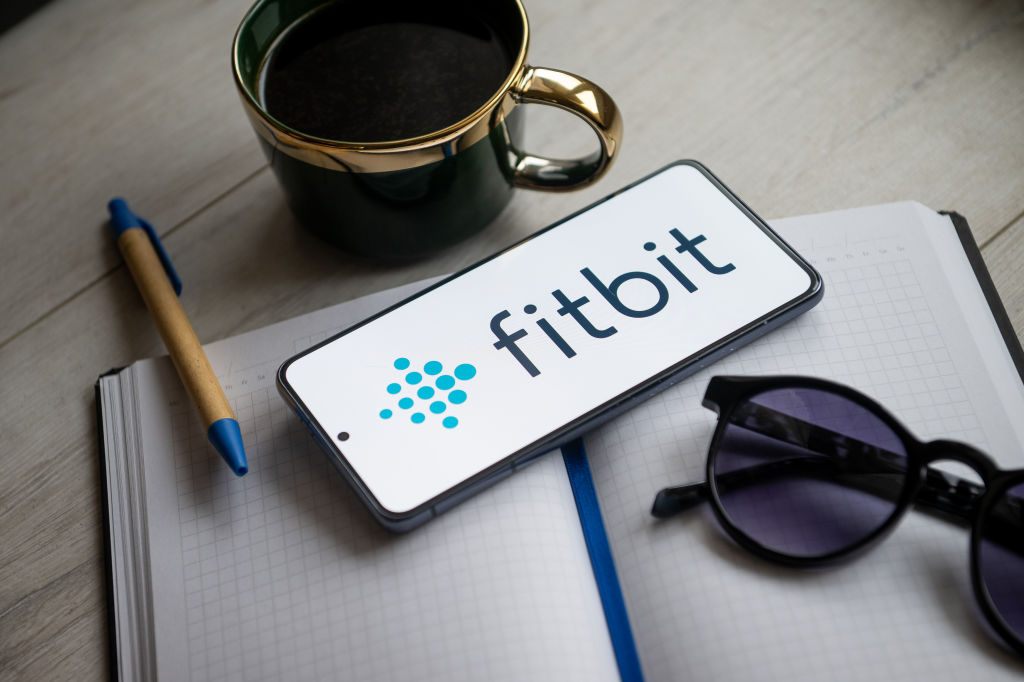 In this photo illustration a Fitbit logo seen displayed on a...