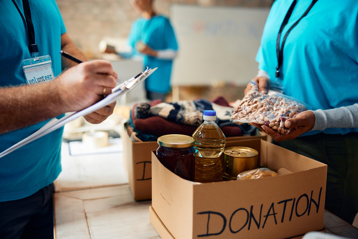 Close up of volunteers packing boxes at donation center - Blackowned, holiday, charity, 
