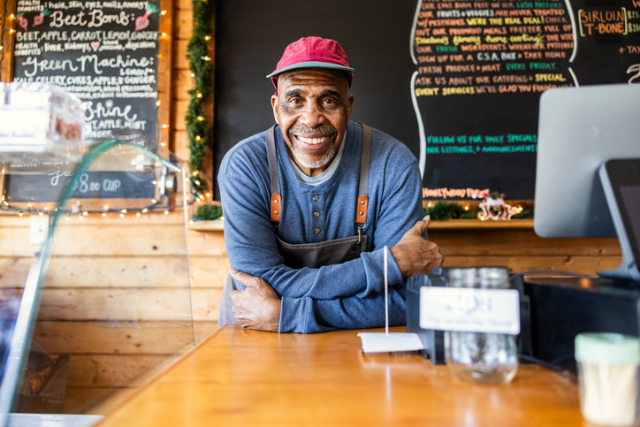 Portrait of senior male cafe owner at front counter