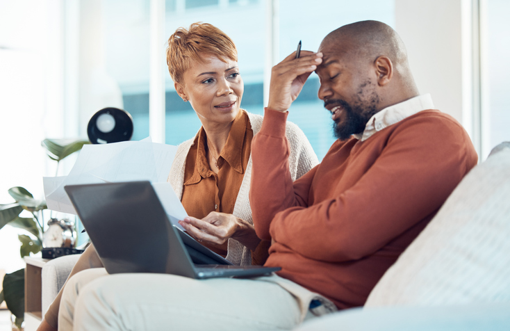 Mature couple, debt and money stress, laptop admin and budget documents, finance anxiety and inflation, savings or tax problem at home. Headache man, frustrated woman and black people bankruptcy risk