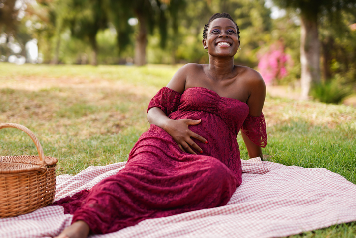 Happy african pregnant woman enjoy day at city park during spring season - Maternity and lifestyle concept