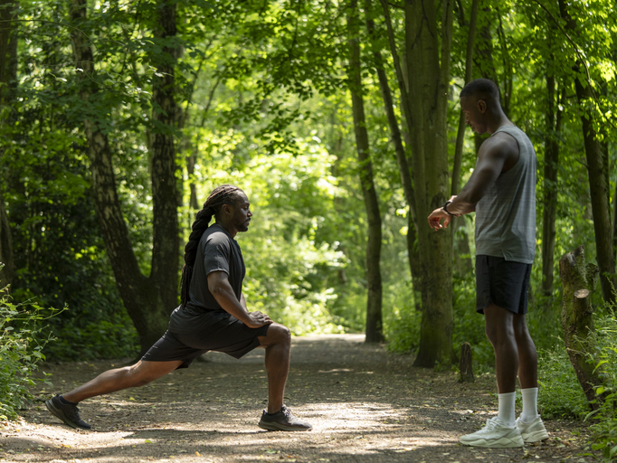 Two men stretching in forest