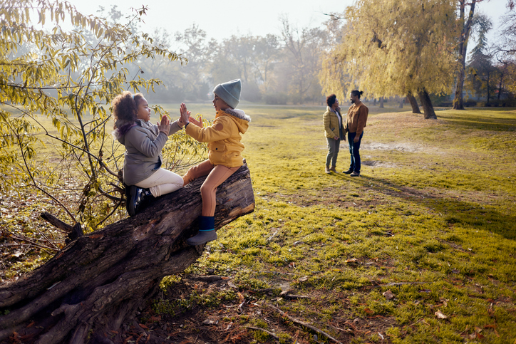Happy black kids having fun on a tree in autumn day.