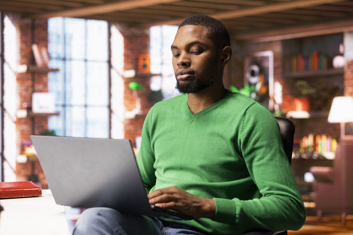 Man enjoying watching TV show on notebook during relaxation time at home