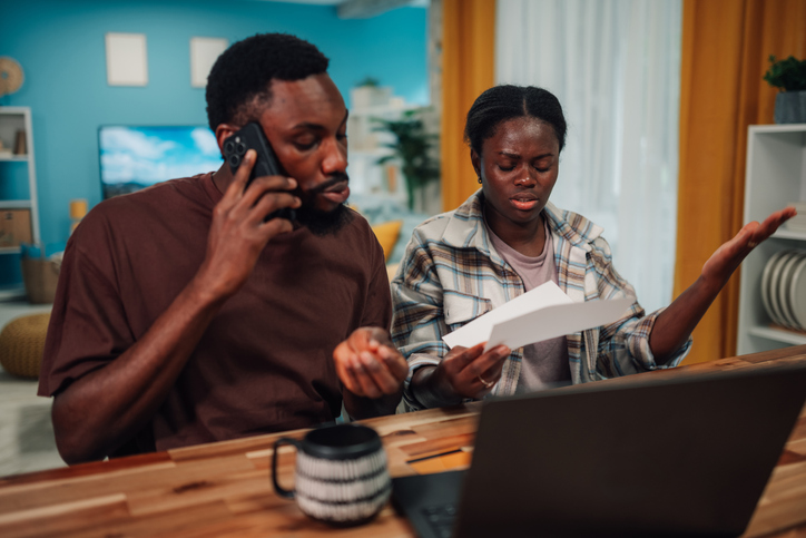 Frustrated couple discussing overdue bills at home