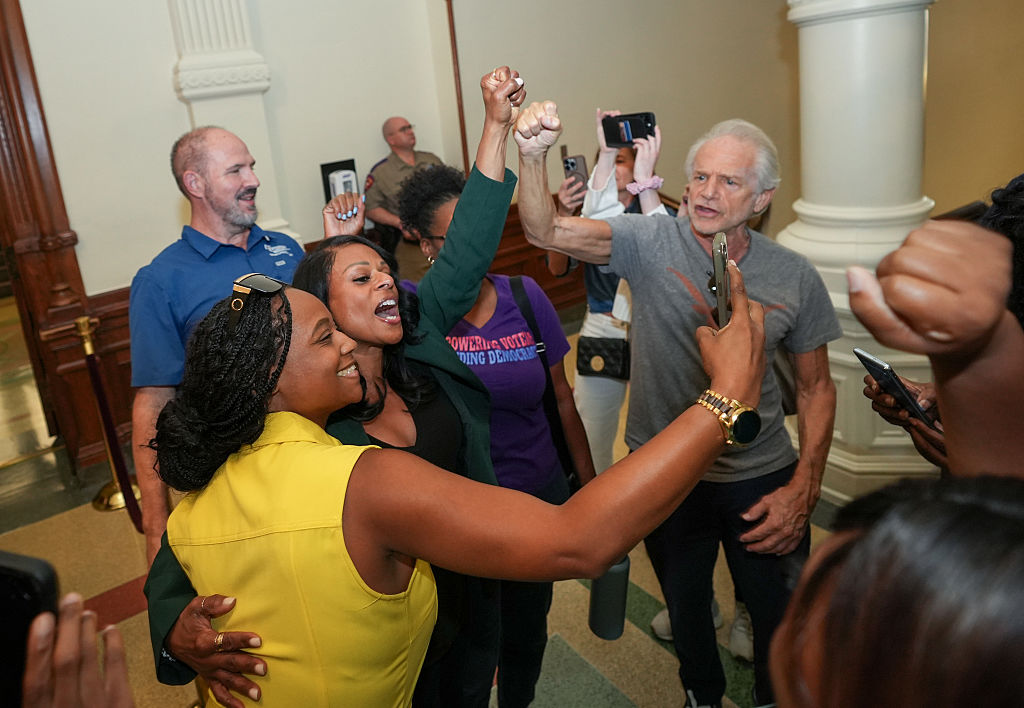 Texas Legislature - Rep. Nicole Collier, D, raises her fist with supporters