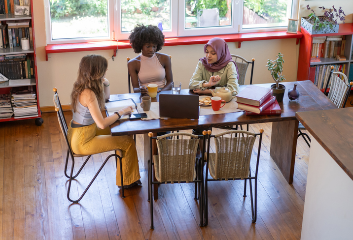 Shot of a group of businesswomen using a laptop during a meeting at work