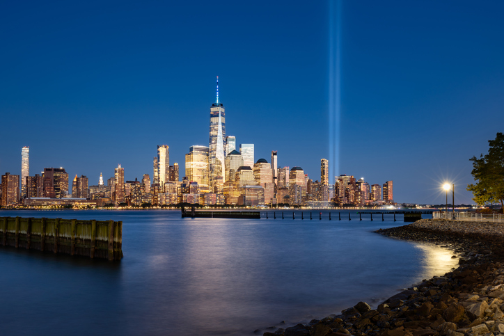 Skyline of Lower Manhattan with Tribute in Light commemoration in evening. World Trade Center skyscrapers and Hudson River, New York City, USA
