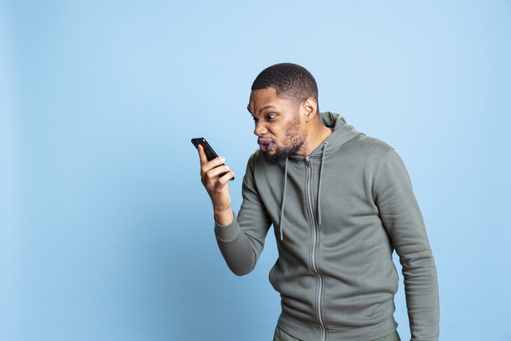 Irked african american man fighting with friends during telephone call