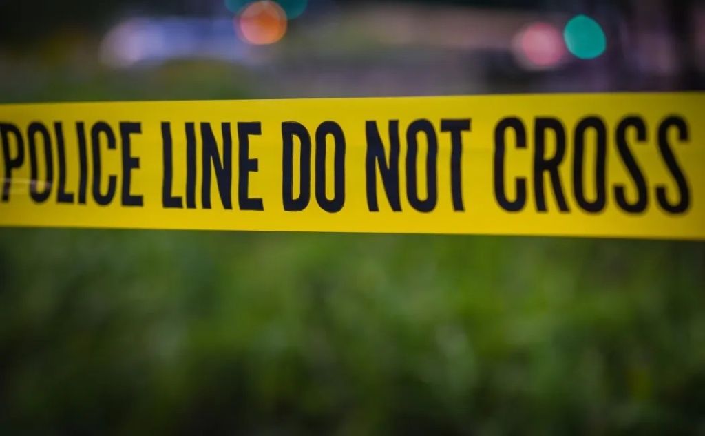 A police car that has its lights on with caution tape in the image