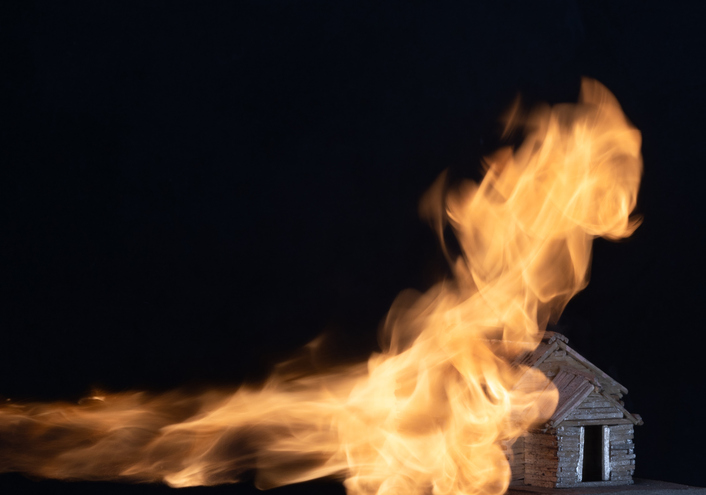 burning house made of matches isolated on a black background